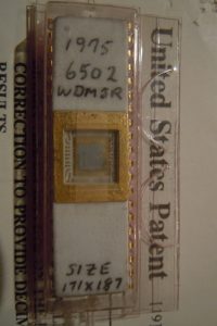 MOS 6502 from 1975 with core exposed.  Sitting on top of printed US Patent for Decimal Correct